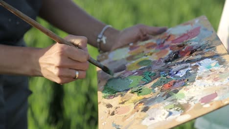 girl artist paints a picture with oil paints