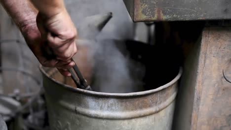 blacksmith putting hot molten metal into water 4k