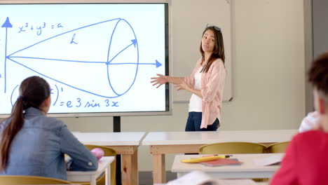 teenage asian girl presents a math problem in a high school classroom