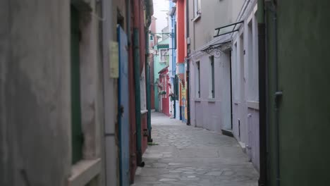 un pintoresco callejón cerca de la colorida casa de bepi en burano, italia