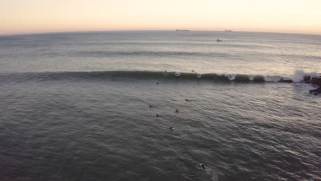 antena, tiro de drone de un niño surfista, surfeando en las olas, en la costa de sao pedro do estoril, en una tarde soleada, en lisboa, portugal