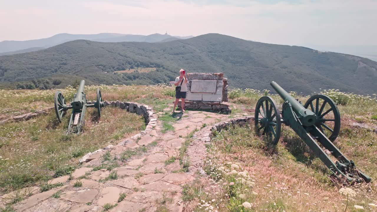 Person at the historic Shipka Pass monument with cannons and mountain views