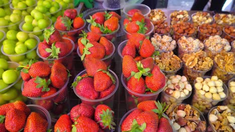 en el mercado de georgia, en vasos de plástico hay frutas secas, nueces,