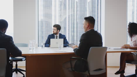 group of business professionals meeting around table in modern office