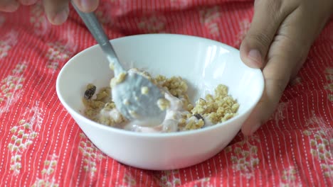 person eating yogurt with granola