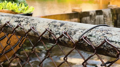 una valla oxidada de enlaces de cadena con chagrin falls en el fondo en el condado de cuyahoga, ohio, estados unidos