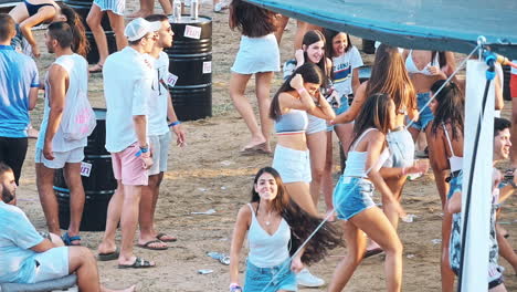 group of friends having fun and dancing on the beach