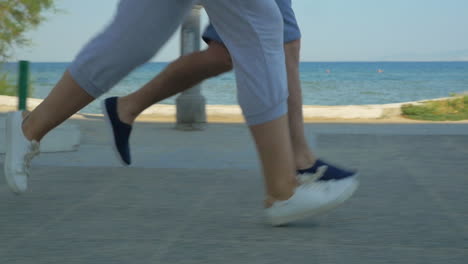 dos personas corriendo a lo largo del mar en la carretera