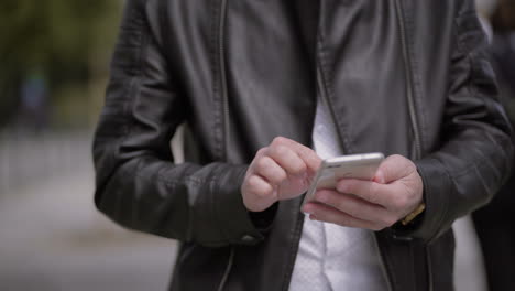 Cropped-shot-of-man-using-cell-phone-outdoor