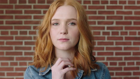 portrait of beautiful red head woman looking shy vulnerable on brick wall background