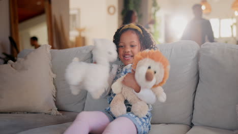 little girl playing with stuffed animals on a sofa