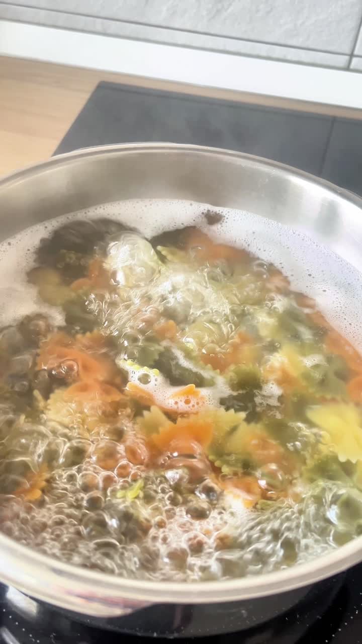 En gryde med mad koger på et komfur. Dampen fra gryden er tyk og hvid.