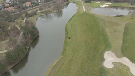 aerial of lawn mower mowing green on golf course