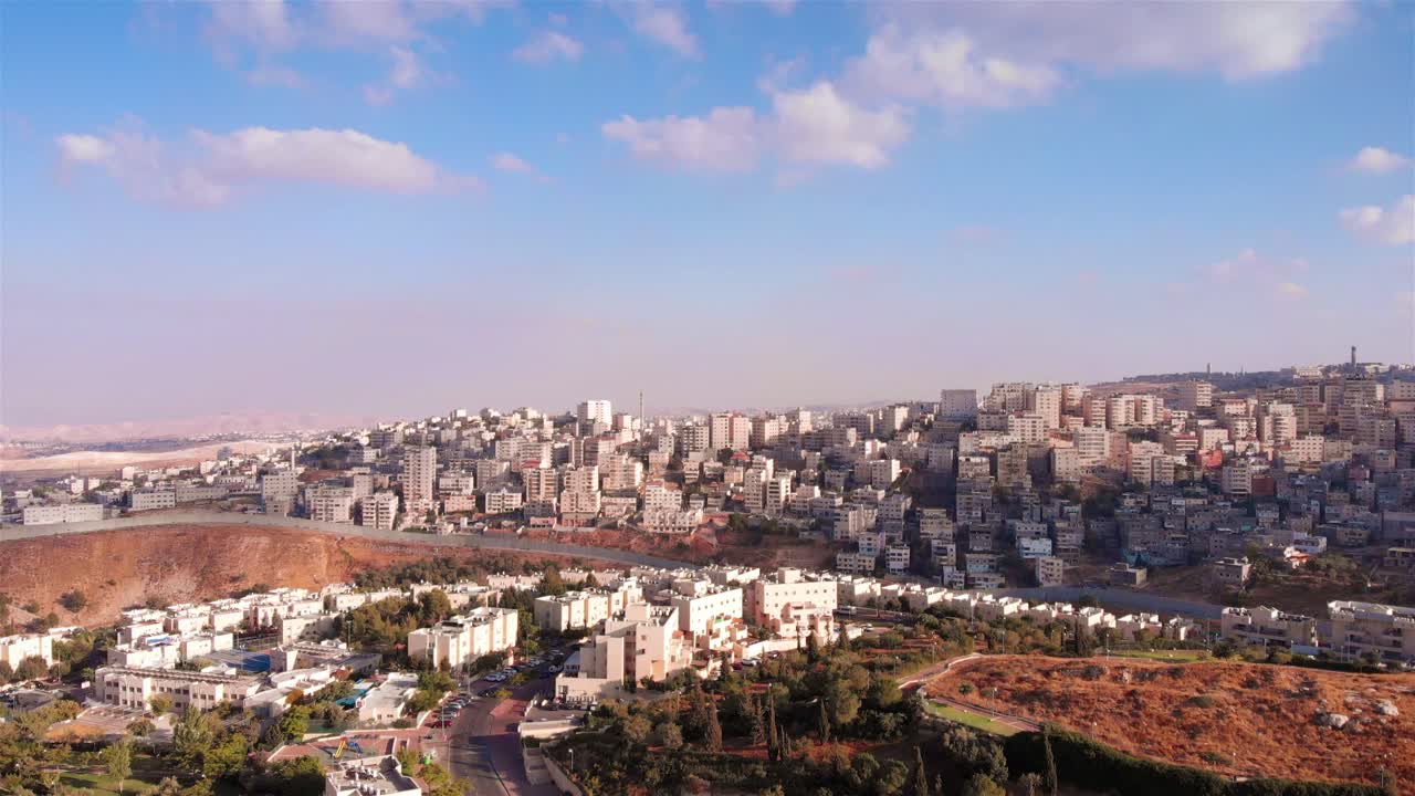 Aerial View of a City on Hills with a Separation Barrier