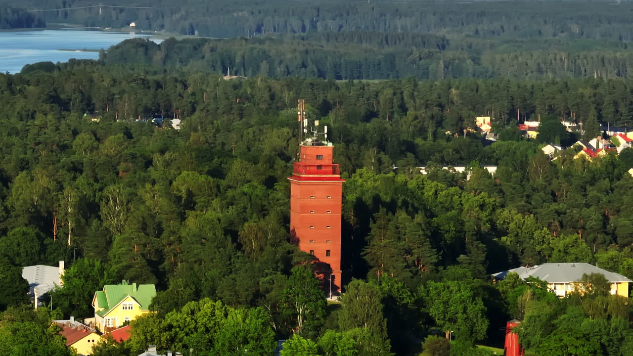 Ripresa con teleobiettivo da drone intorno alla torre dell'acqua di Ekenas, tramonto estivo in Finlandia