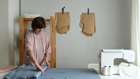 seamstress rolling up fabric in workshop