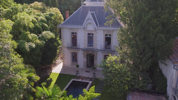 Nestled within a verdant garden, the beautiful stone cottage is accompanied by a shimmering pool, creating a tranquil oasis