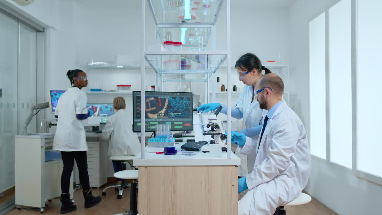 Scientist coworkers testing liquid using tube test and microscope