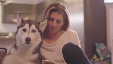 beautiful young woman relaxing in her living room with her adorable dog.