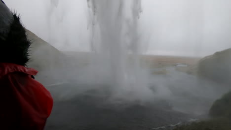 Hermosa-Toma-Detrás-De-La-Cascada-Islandesa-Seljalandsfoss-Y-Donde-Una-Mujer-Admira-La-Belleza-Y-La-Fuerza-Del-Agua-Que-Cae