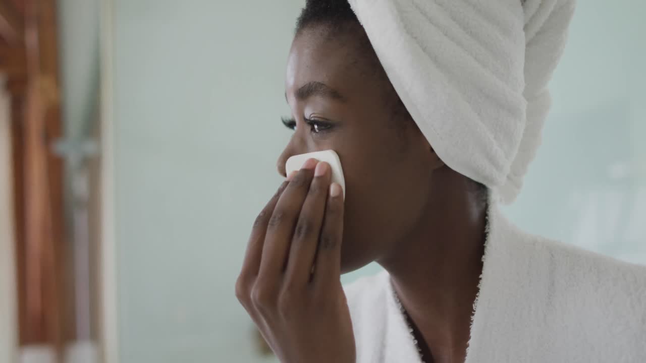 retrato de una mujer afroamericana atractiva quitando el maquillaje en el baño