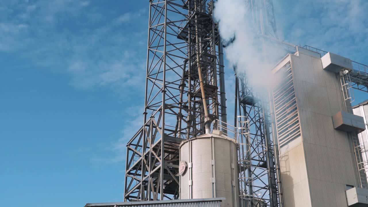 Industrial Plant Emitting Smoke Against a Blue Sky