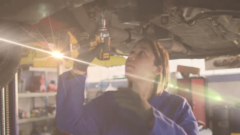 animation of glowing light over caucasian female car mechanic in workshop