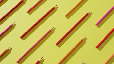 video of multi-colored crayons in a row on a yellow background