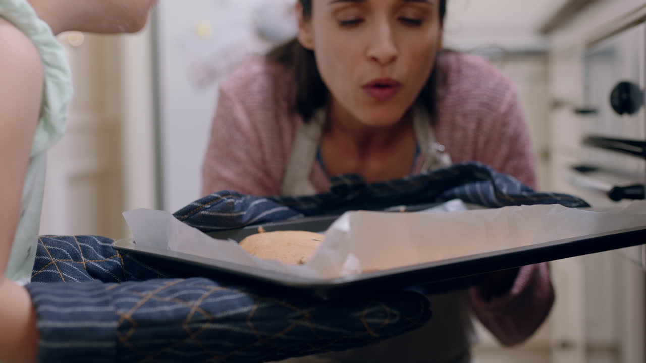madre e hija horneando en la cocina disfrutando del aroma de galletas recién horneadas fuera del horno usando guantes de horno niña ayudando a su madre el fin de semana