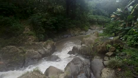 Aerial-forward-flight-over-tropical-Gitgit-Waterfall-with-Stream-between-rainforest-in-Bali