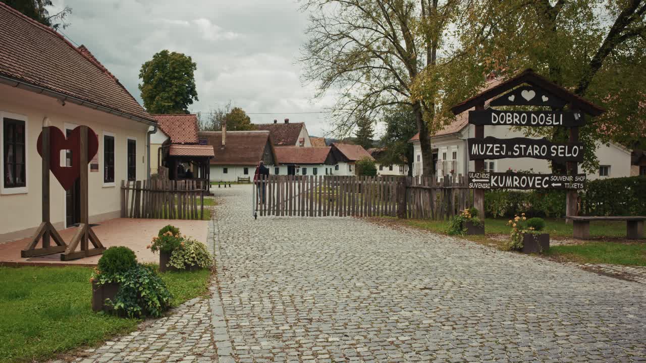 Entrance to Staro Selo Museum in Kumrovec, Croatia, with cobblestone path and traditional houses