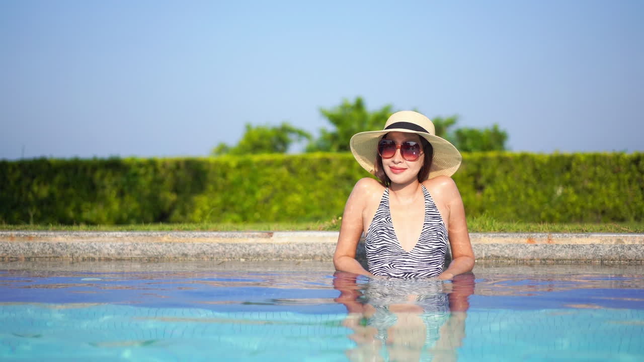 Medium shot of an Asian woman relaxing in a pool