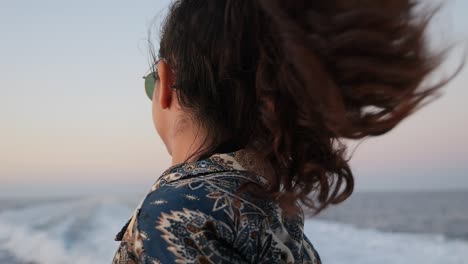 a woman enjoys the wind in her hair while on a boat ride, close-up slow motion