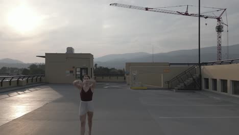 bailarina de ballet persiguiendo a través de un techo parkade en cámara lenta