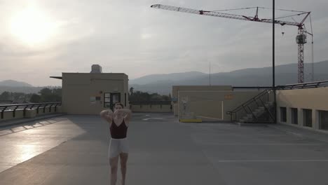 ballet dancer chasing across a parkade roof in slow motion