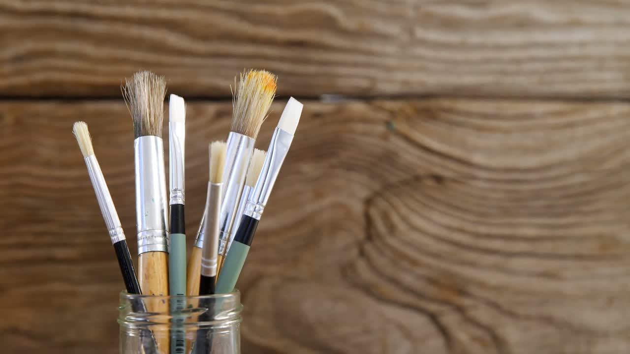 varios pinceles en contenedores de plástico