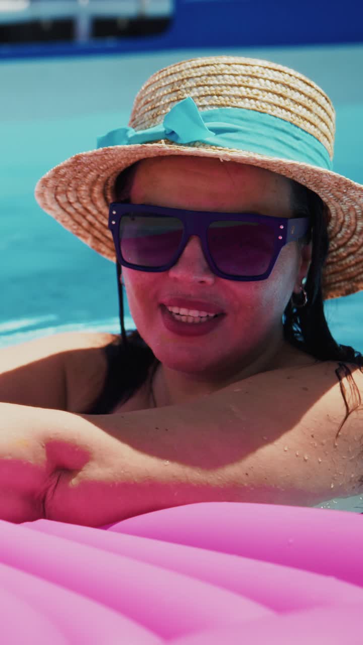 Enjoying a Relaxing Summer Day by the Pool: A Woman in a Straw Hat and Stylish Sunglasses, Embracing the Sun and Water Fun