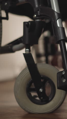 legs of woman with spinal cord injury sitting in wheelchair on blurred background. patient with disability uses medical equipment to move closeup