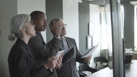 african american financial advisor presenting trading charts with his team