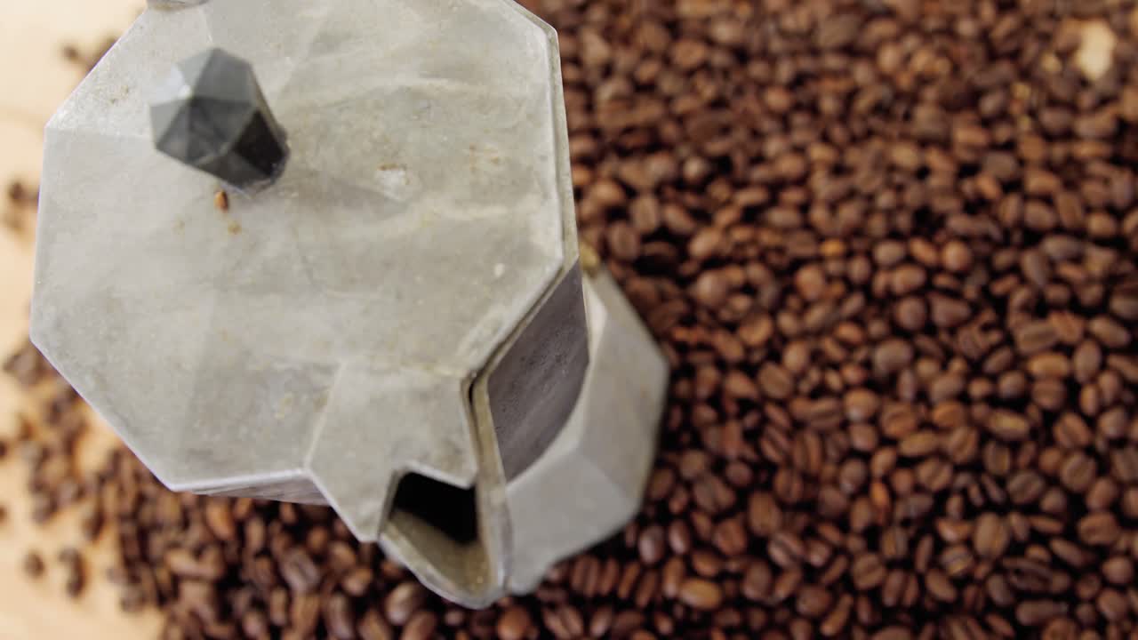 granos de café con cafetera metálica