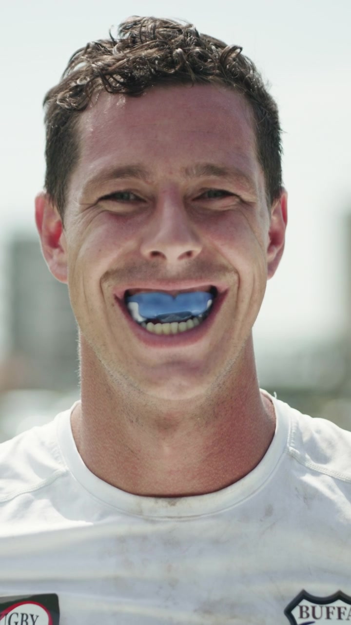 Rugby Player Smiling While Wearing a Blue Mouthguard
