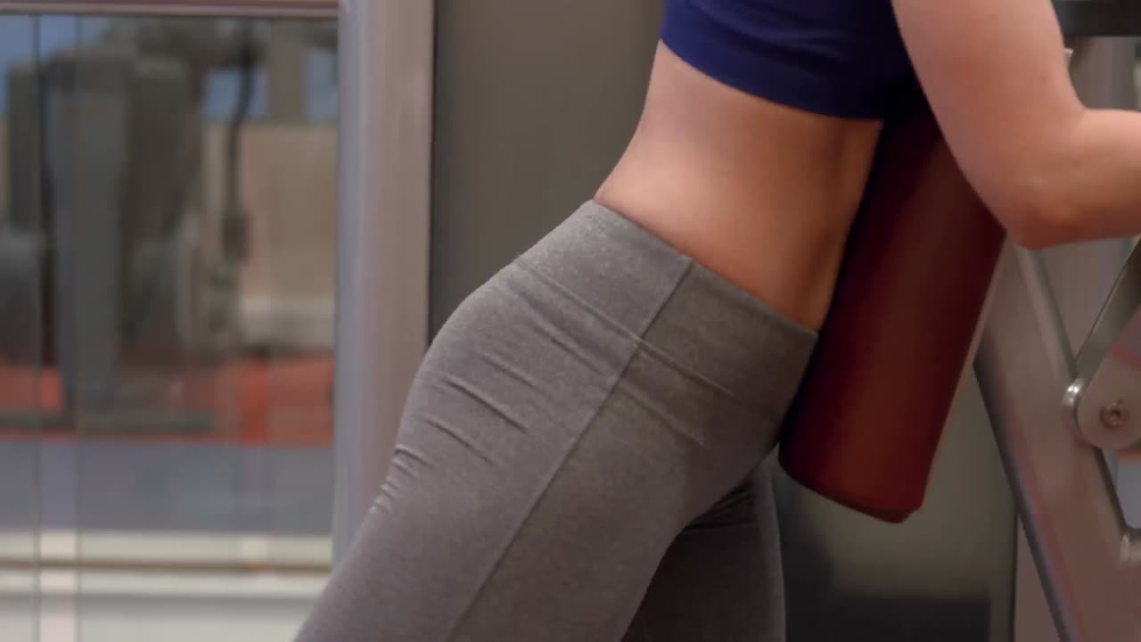 체육관 에서 무게 기계 를 사용하는 여자