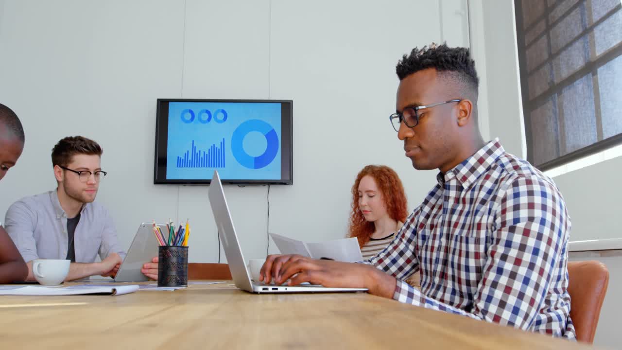 Side view of young mixed-race business team working in meeting room of modern office 4k