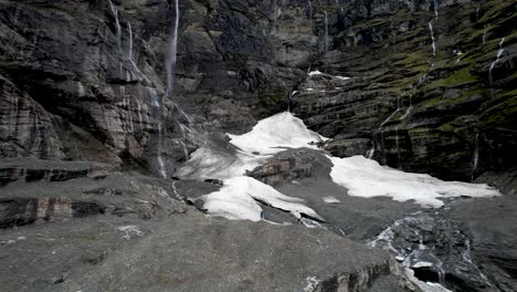 spectacular wall of waterfalls from hanging glacier and man on lookout