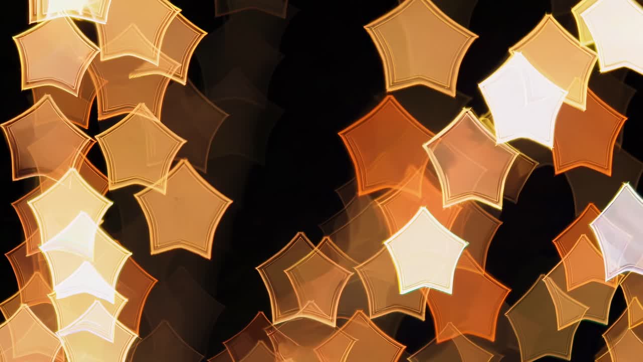 Soft glowing stars in various shades of gold, white, and brown float gently on a dark background, creating a magical and tranquil atmosphere