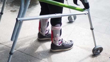 person with a broken leg using a walker