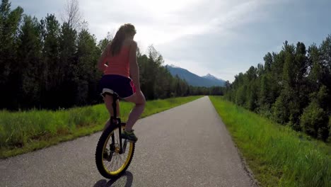 woman riding unicycle on the road 4k