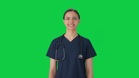 Happy-Indian-female-doctor-in-scrub-suit-smiling-Green-screen