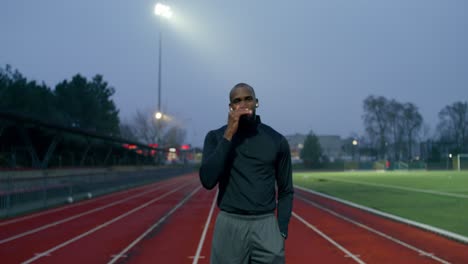 man on a running track at night