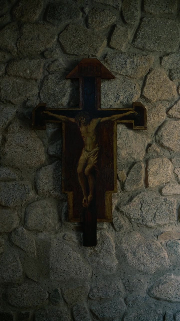 Crucifixo de Madeira Montado em uma Parede de Pedra Rústica